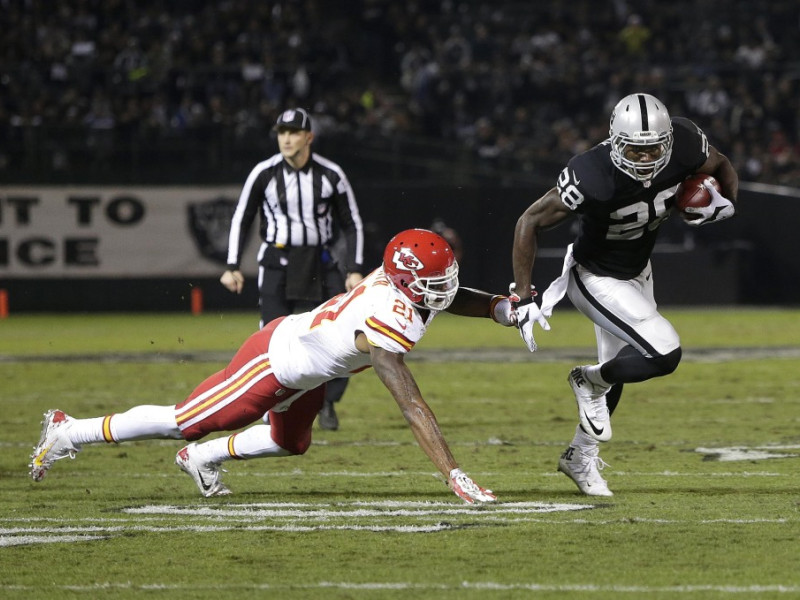 Oakland Raiders running back Latavius Murray (28) runs past Kansas City Chiefs cornerback Sean Smith (21) to score on a 11-yard touchdown run during the first quarter of an NFL football game in Oakland, Calif., Thursday, Nov. 20, 2014. (AP Photo/Marcio Jose Sanchez)